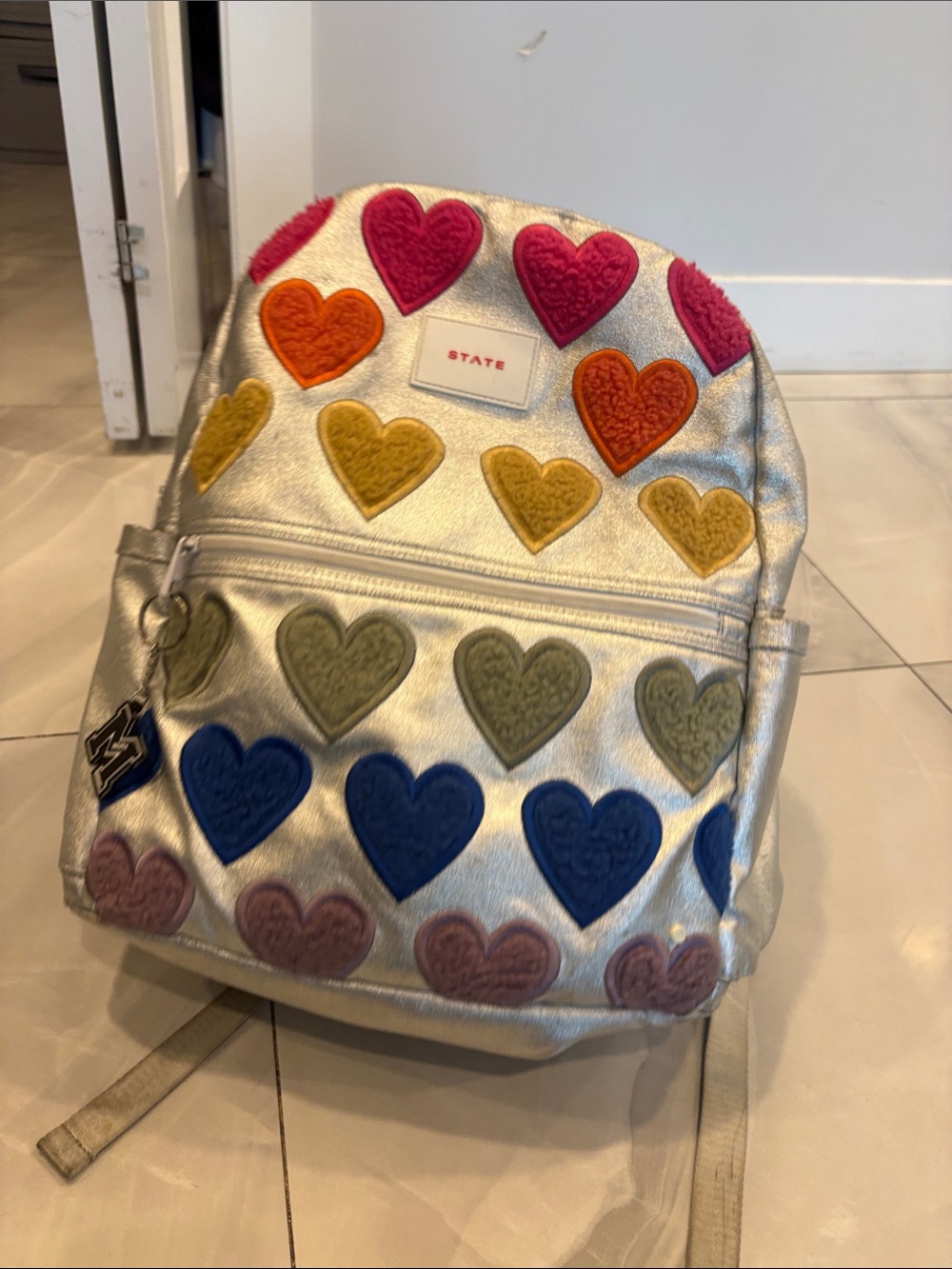 1. State Metallic Silver Backpack with Multi-Color Heart Patches